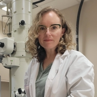 Dr. Sarah K Carmichael, Appalachian State University, in front of a transmission electron microscope